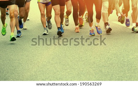 Unidentified marathon athletes competing in fitness and healthy active lifestyle feet on road