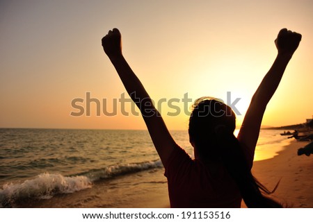 cheering woman open arms at sunset seaside beach