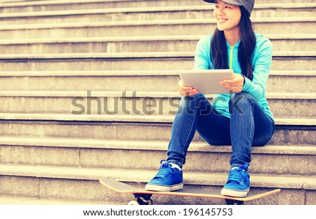 woman skateboarder use digital tablet sit on stairs