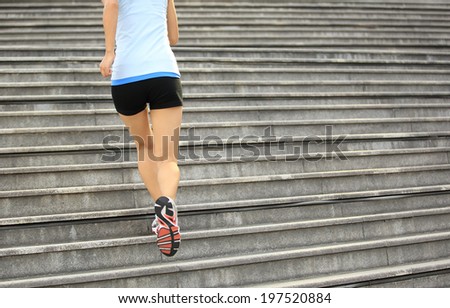 Runner athlete running on stairs. woman fitness jogging workout wellness concept.