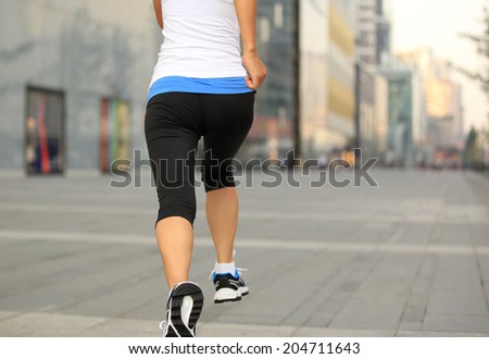 Runner athlete running on city road. woman fitness jogging workout wellness concept.