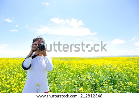 woman photographer taking photo in cole flower field