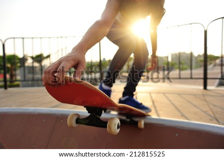 young woman skateboarding at sunrise skatepark