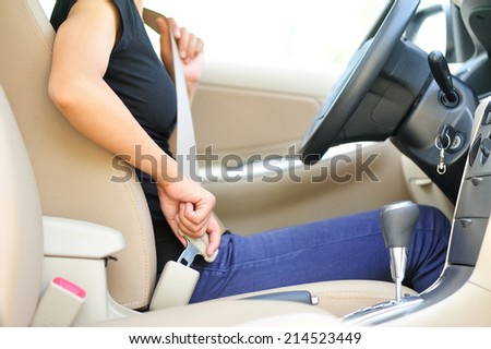 woman driver buckle up the seat belt before driving car
