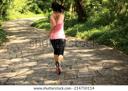 Runner athlete running on forest trail. woman fitness jogging workout wellness concept.