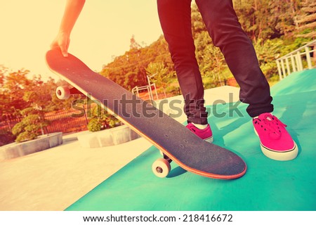 skateboarding woman legs at sunrise skatepark