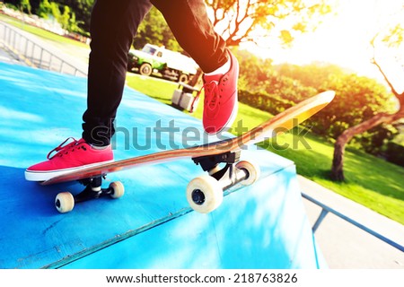 skateboarding woman legs at sunrise skatepark