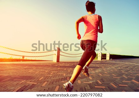 Runner athlete running at seaside. woman fitness jogging workout wellness concept.