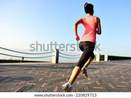Runner athlete running at seaside. woman fitness jogging workout wellness concept.