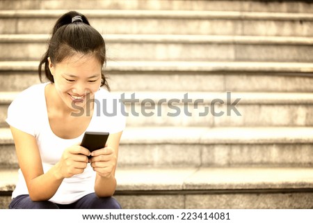 young woman use her cellphone sit on stairs
