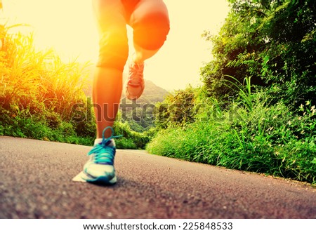 young fitness woman runner legs running at forest trail