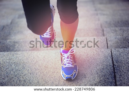 sports woman legs running up on stone stairs