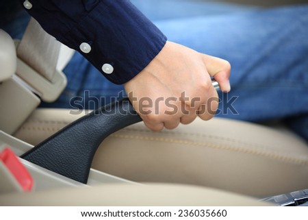 driver pulling the hand brake in car