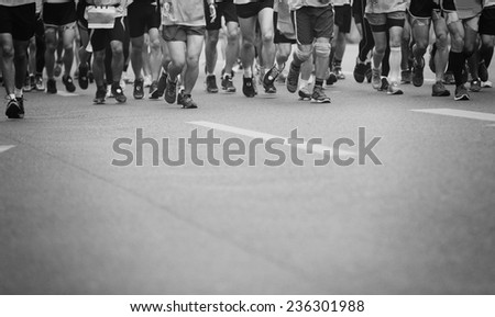 Unidentified marathon athletes legs running on  city road