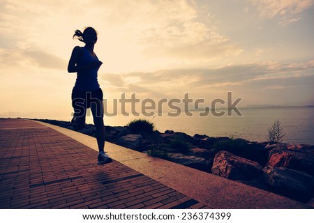 Runner athlete running at seaside. woman fitness silhouette sunrise jogging workout wellness concept.