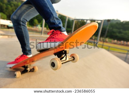 young woman legs skateboarding at skatepark