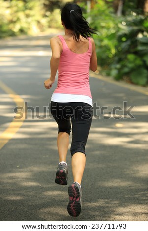 Runner athlete running at road. woman fitness jogging workout wellness concept.