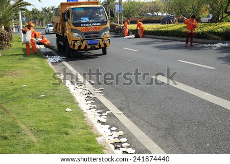XIAMEN,CHINA - JANUARY 3:  Cleaners cleaning the used water paper cup after marathon running on street at Xiamen International Marathon JANUARY 3, 2015 in Xiamen, China