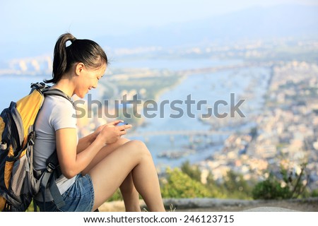 young woman hiker use smart phone mountain peak