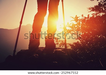 woman hiker legs on mountain peak rock