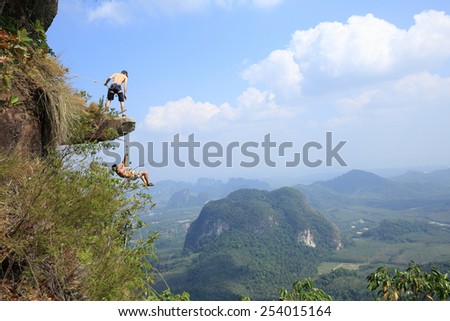 KRABI,THAILAND- JANUARY 23: Two man climbing rock on the mountain cliff ,Krabi, JANUARY 23 2015 in Krabi Thailand