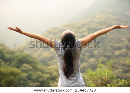 cheering woman enjoy the beautiful view at mountain peak