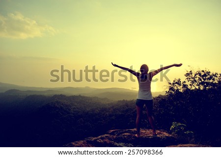 cheering woman open arms mountain peak