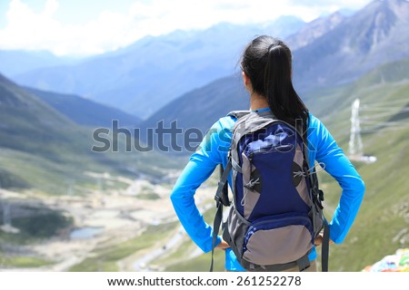 woman hiker enjoy the view at plateau mountain peak in tibet,china