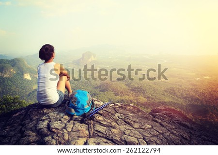 woman hiker enjoy the view at sunset mountain peak cliff