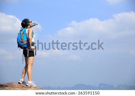 woman hiker drink water mountain peak cliff
