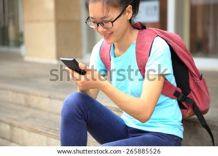 young woman college student use cellphone sit on stairs