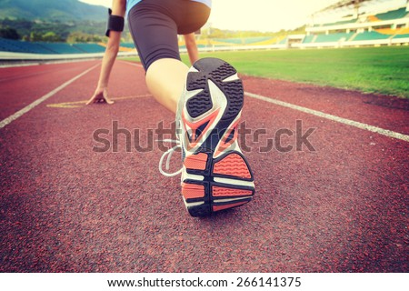 young woman runner getting ready for a run on track