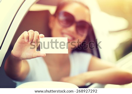 woman driver sit in car hold one blank business card