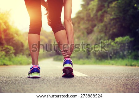 woman runner hold her sports injured leg