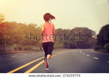 Runner athlete running at road. woman fitness jogging workout wellness concept.
