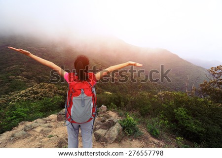 cheering woman enjoy the beautiful view at mountain peak
