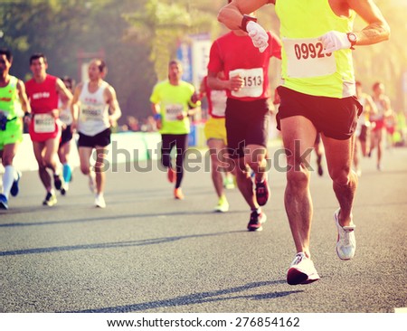 Marathon running race,male runner checking the time from his sports watch