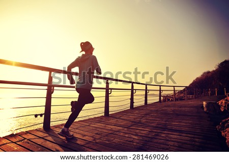 healthy lifestyle sports woman running on wooden boardwalk seaside