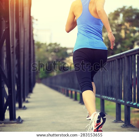 Runner athlete running on iron bridge. woman fitness jogging workout wellness concept.
