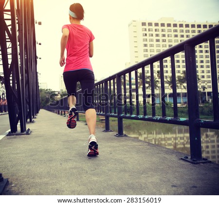 Runner athlete running on iron bridge. woman fitness jogging workout wellness concept.