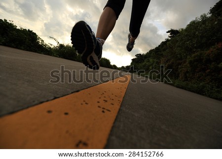 Runner athlete running at seaside road. woman fitness  jogging workout wellness concept.