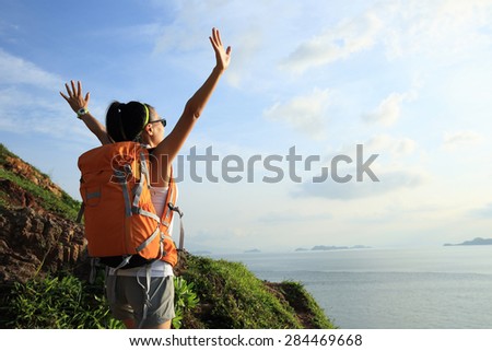 cheering woman backpacker on  seaside mountain  enjoy the view