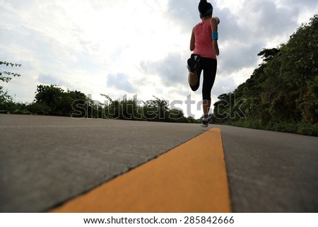 Runner athlete running at seaside road. woman fitness jogging workout wellness concept.