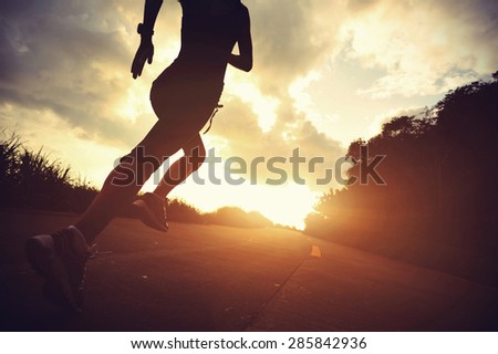 Runner athlete running at seaside road. woman fitness silhouette sunrise jogging workout wellness concept.