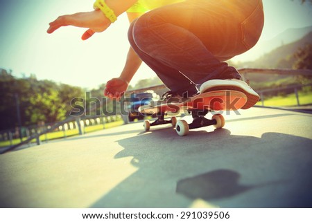skateboarder legs ready to do a trick ollie at skatepark