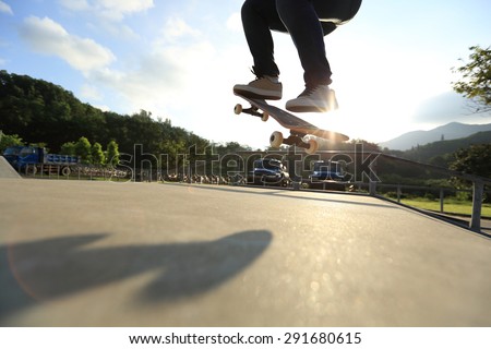 skateboarder legs  do a trick ollie at skatepark
