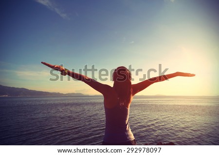 young cheering woman jogger open arms at sunrise seaside,vintage effect