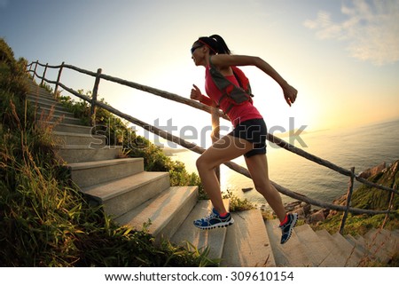 fitness woman runner trail running on seaside mountain stairs, training for cross country running.