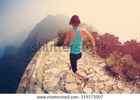 Runner athlete running on chinese great wall . woman fitness jogging workout wellness concept.