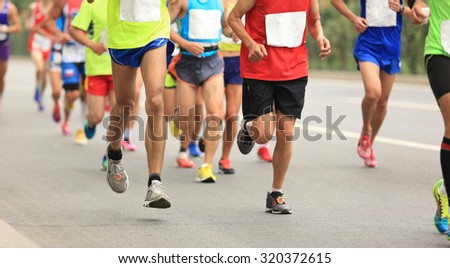 Many marathon runners running on city road